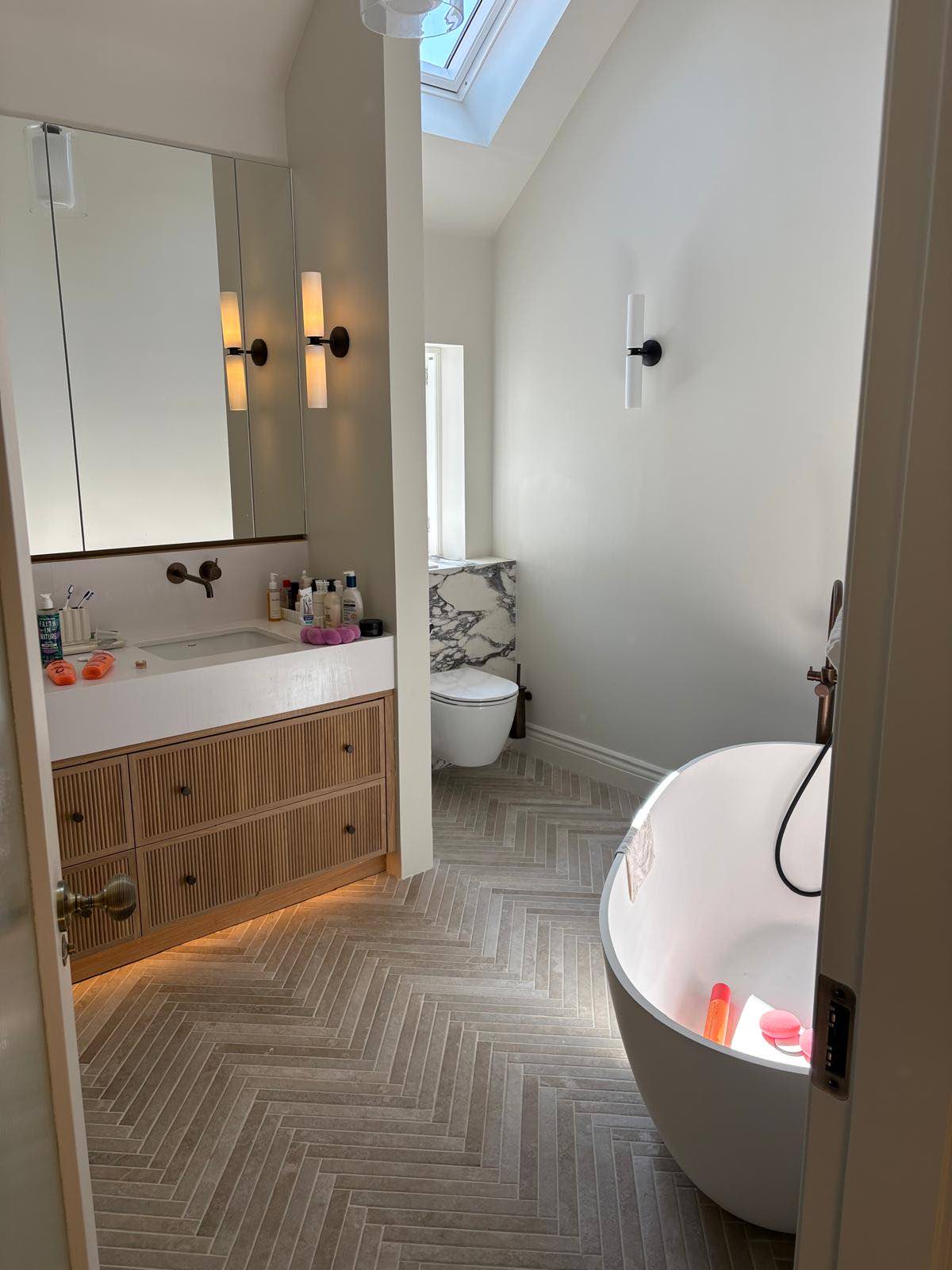 Bathroom with freestanding bath and herringbone floor