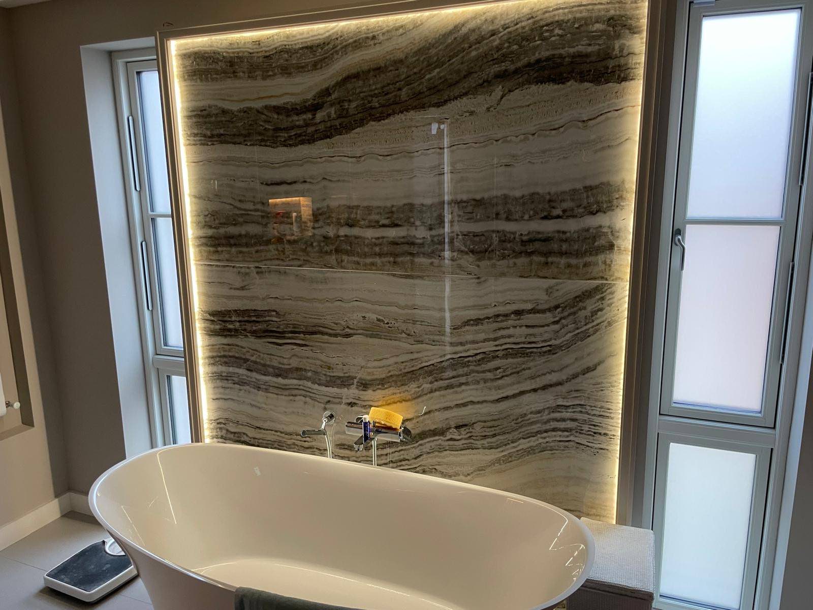 Bookmatched stone bathroom with freestanding bath