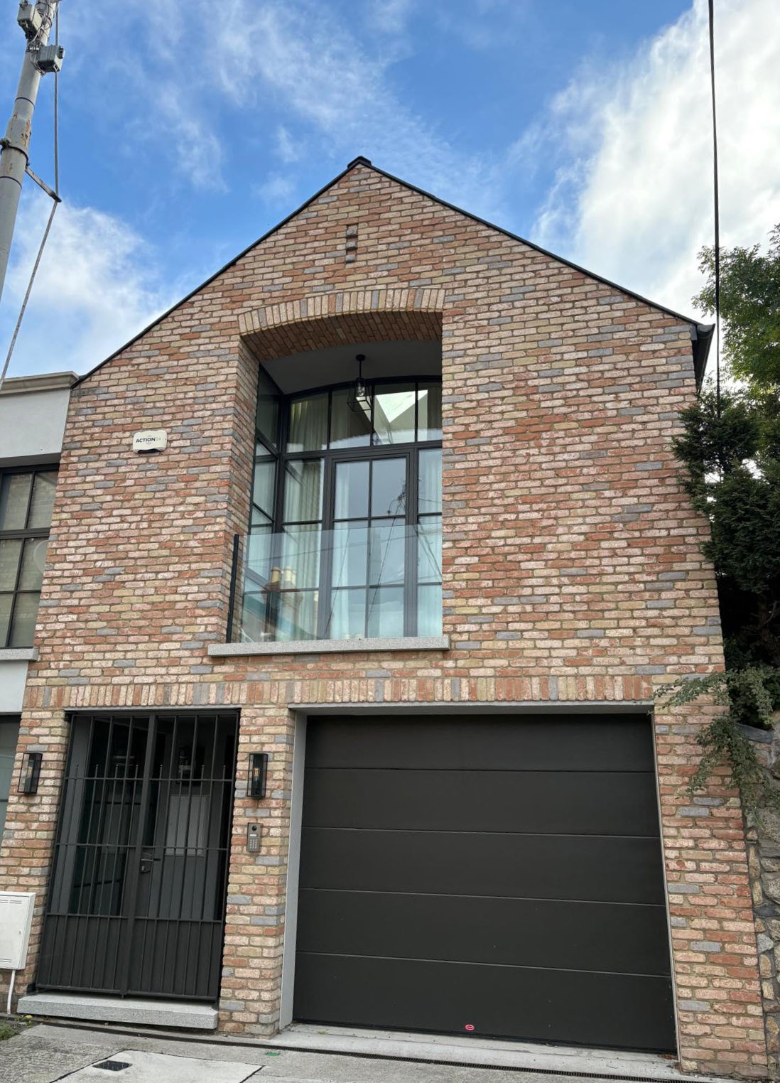 The Mews, Dublin 6: brick front elevation with arched gable window and glazed balcony