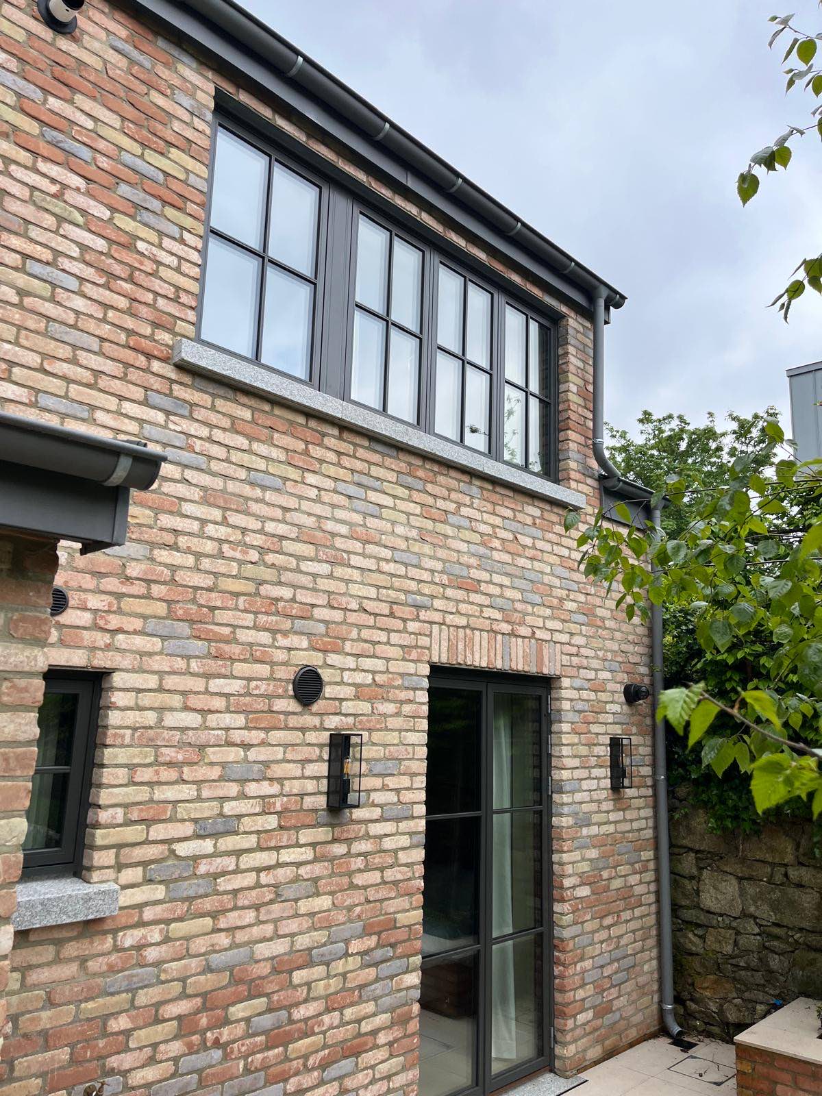 Side elevation in brick with dark aluminium windows